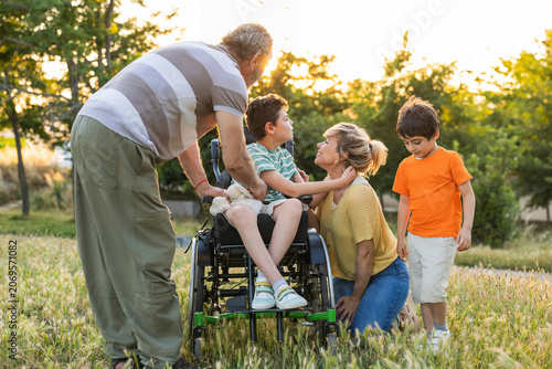 Family enjoying park time with son in wheelchair