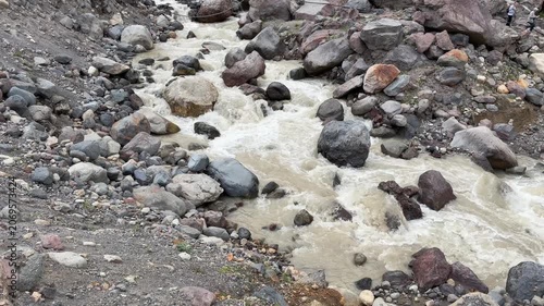 River water flows rapidly over various rocks in a rocky terrain, highlighting the natural landscape and geological features of the area