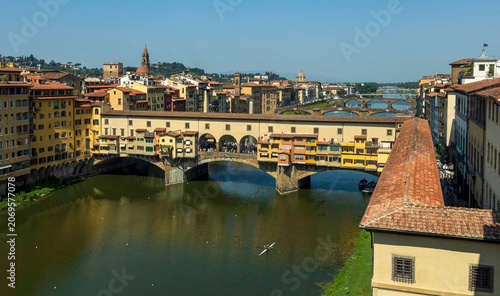 Obraz na plátne View of the historic Ponte Vecchio bridge over the Arno River in Florence, Italy, with traditional buildings and Renaissance city architecture in daylight