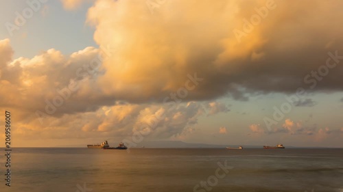 Time lapse of the beautiful morning clouds over the ocean in Bali Indonesia at sunrise. Cardgo ships can be seen in the distance.
