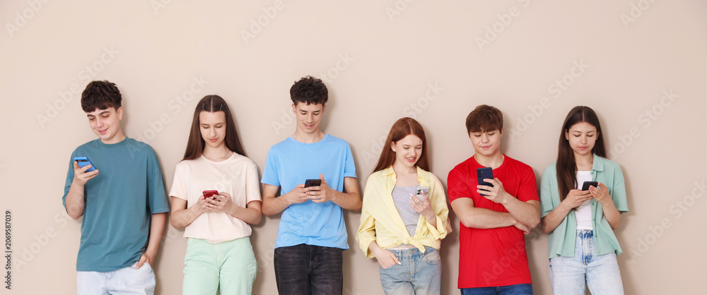 Obraz premium Group of teenagers with different smartphones indoors