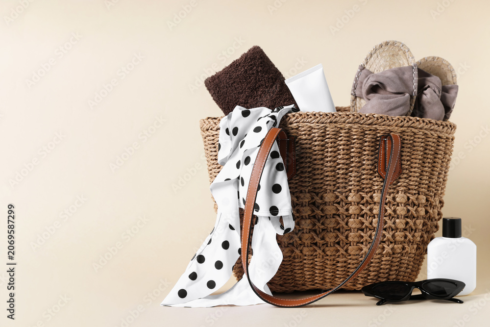 Obraz premium Bag with beach accessories on beige background. Space for text