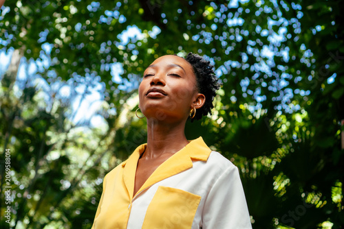 Young black woman breathing deep fresh air outdoor.