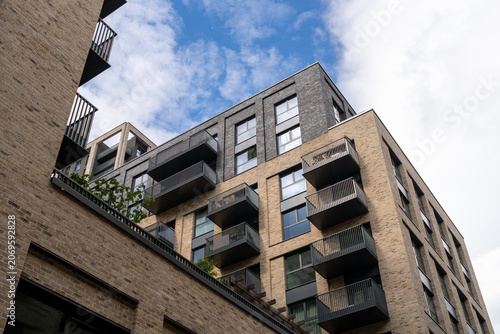 Modern Urban Apartment Building Exterior With Balconies Against Cloudy Sky