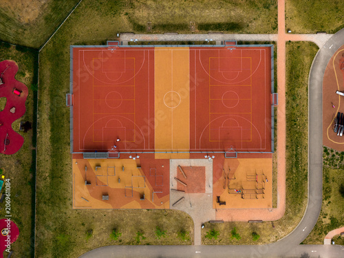 Aerial view of a colorful multi-sport court and adjacent playground area with rubberized surfaces in Brno, South Moravian Region, Czechia.