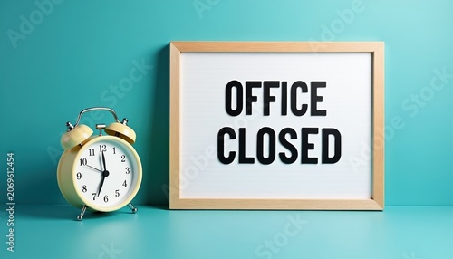Retro alarm clock and wooden frame display OFFICE CLOSED message. Time to stop work, take a break, or start holiday. Quiet, no people, clean background signals end of business day.