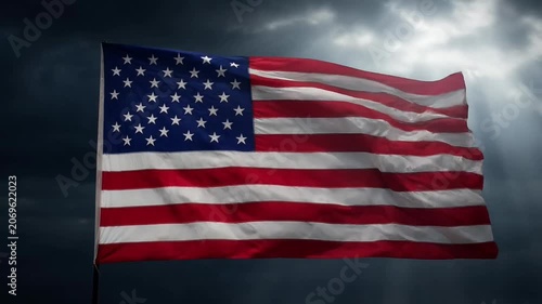 Waving American flag against a dramatic stormy sky with sun rays