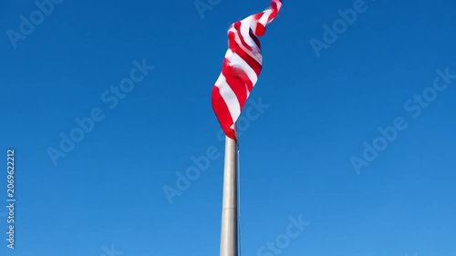 Patriotic flag waving proudly against a clear blue sky.