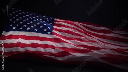 Waving American flag against a dark, dramatic background.