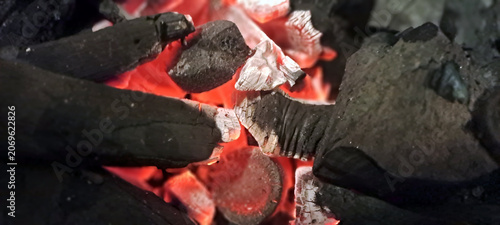 Burning charcoal embers glowing with intense red heat