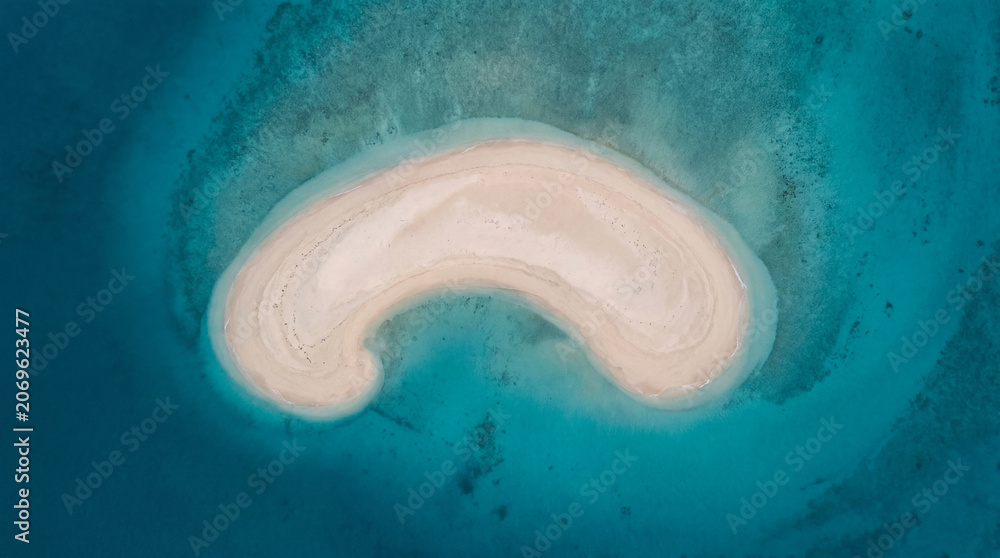 Fototapeta premium Beautiful Aerial Drone Shot Of A Crescent Sandbar Emerging From Deep Turquoise Ocean Waters Stock