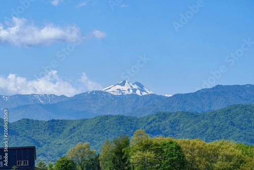初夏の青空と新緑に映える残雪の美しい白山連峰の山並み 日本の豊かな自然風景