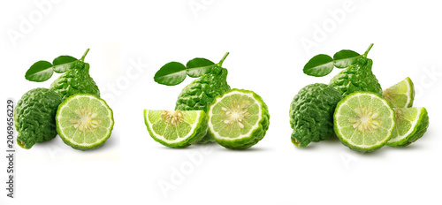 Collection of fresh bergamot (kaffir lime) including whole fruit, halves, and slices with green leaves. Essential herbal ingredient isolated on white background.