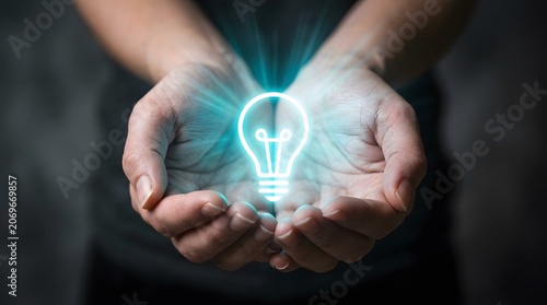 Hands holding glowing light bulb symbolizing idea or innovation