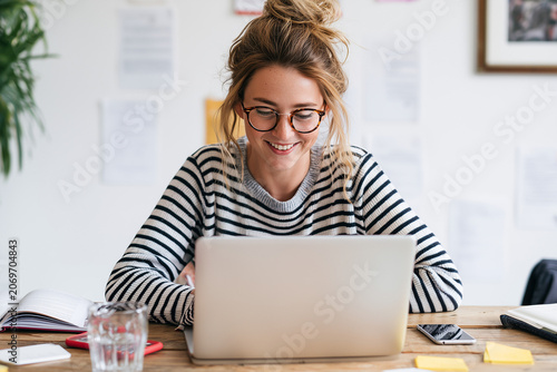 The woman builds a calm workspace at her home office desk 
