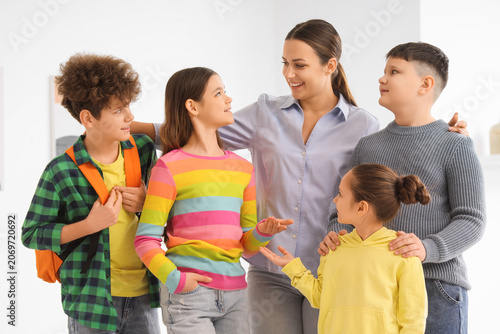 Female guide with group of children at exhibition in art gallery