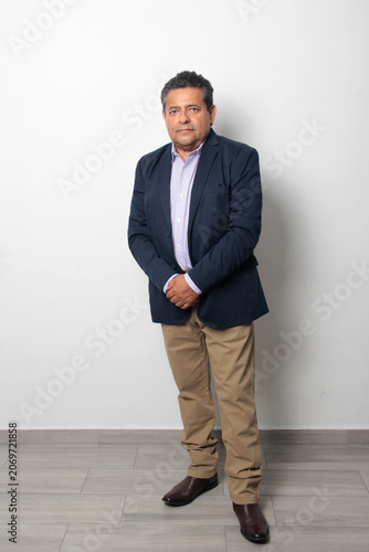 60-year-old Latino man with dark skin appears happy and at peace, enjoying a successful professional and personal life