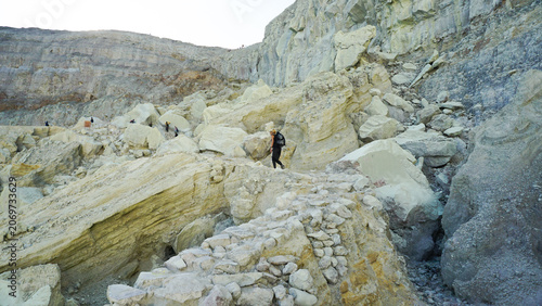 Woman Hiking Through Rocky Terrain at Ijen Crater, Banyuwangi Indonesia.