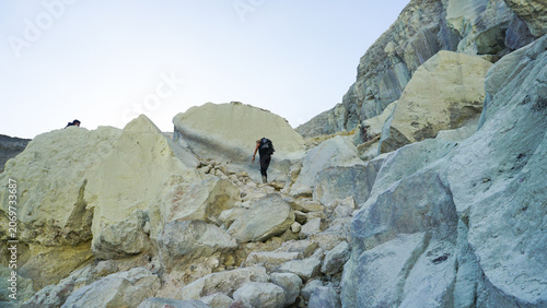 Woman Hiking Through Rocky Terrain at Ijen Crater, Banyuwangi Indonesia.
