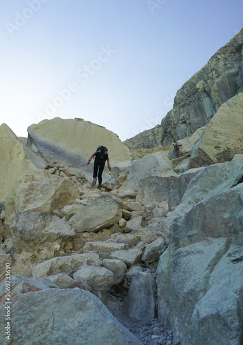 Woman Hiking Through Rocky Terrain at Ijen Crater, Banyuwangi Indonesia.