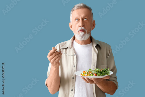 Mature man with tasty veget...