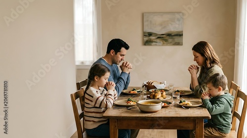 Family praying together at the dining table before meal