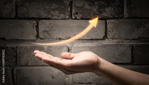 Rising arrow above an open hand on a textured background, representing progress, profitability, market expansion, and strategic achievement.