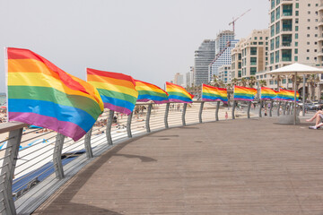 Rows of flags erected at the beach wave proudly in the wind on the Israeli beach for Pride month celebrations