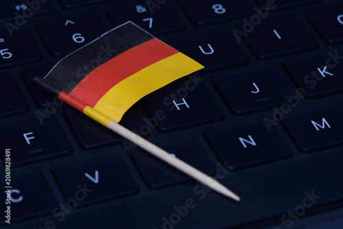 German flag on computer keyboard symbolizing digital economy, IT regulations, online work and high-tech job market in Germany.