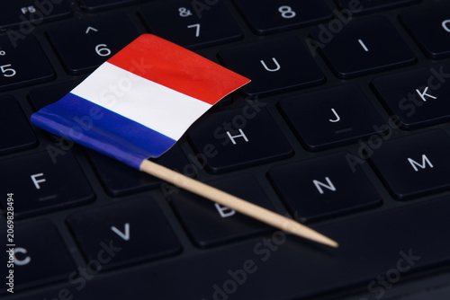 French flag on computer keyboard symbolizing digital economy, IT regulations, online work and high-tech job market in France.