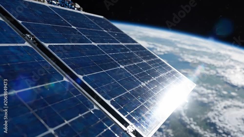 Solar panel array of Earth observation satellite shows silicon cells in grid pattern. Sunlight reflects off metallic edges. Earth partially visible. Orbital mechanics concept