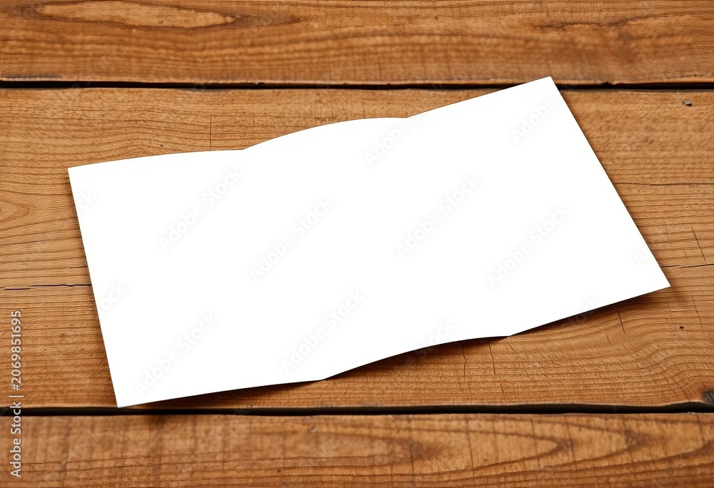 Fototapeta premium High-resolution image of a blank tri-fold brochure mockup on a textured wooden surface, communication, texture