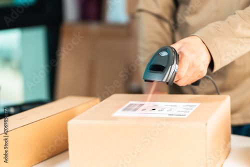 Worker Scanning Shipping Label on Package for Logistics Tracking