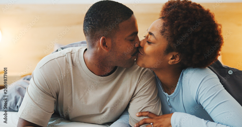 Obraz premium Wake up, kiss or couple in bed with love, partner care or bonding together in connection. Tender, loyalty or African people with affection, romantic moment or morning routine in healthy relationship.