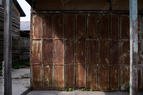 Weathered Folding Metal Shop Door on Traditional Wooden Building
