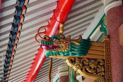 Photography Intricate dragon carving adorns the ornate roof of a traditional Asian temple st