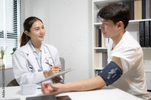 Fotografía Doctor records patient's blood pressure reading