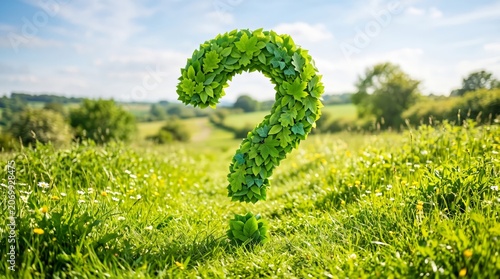 Large green question mark made of leaves in a sunny field
