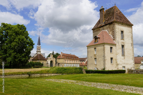 Detached building, tower at Commarin Castle. With the village church in the background.