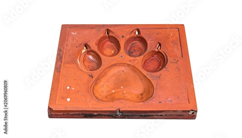 A square, aged wooden mold shows the impression of an animal paw print, ready for a cast