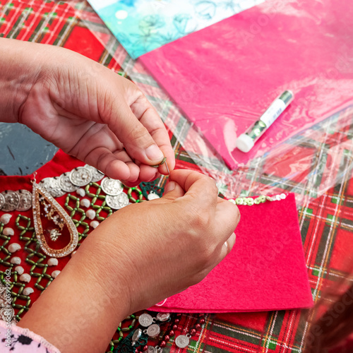 Women's hands create beautiful jewelry using felt and beads