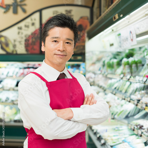 Fotografie 青果売り場で腕を組む40代男性店員