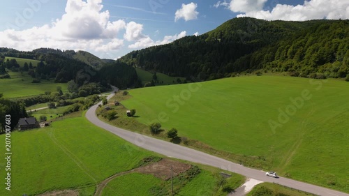 Drone Shot of a White Car Driving Along a Mountain Road near Cicmany, Slovakia