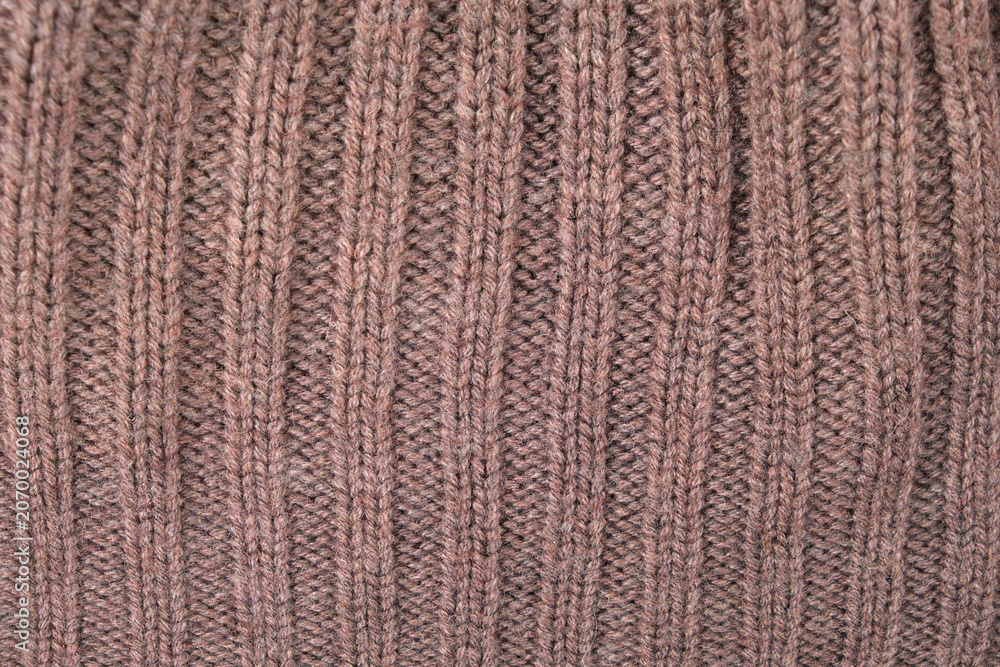 Fototapeta premium Brown knitted wool fabric texture. Soft sweater surface with rib pattern. Close up view of textile material for clothing design and construction. Winter apparel background concept.