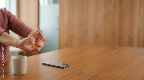 Professional woman stretching wrists at office desk for workplace wellness.