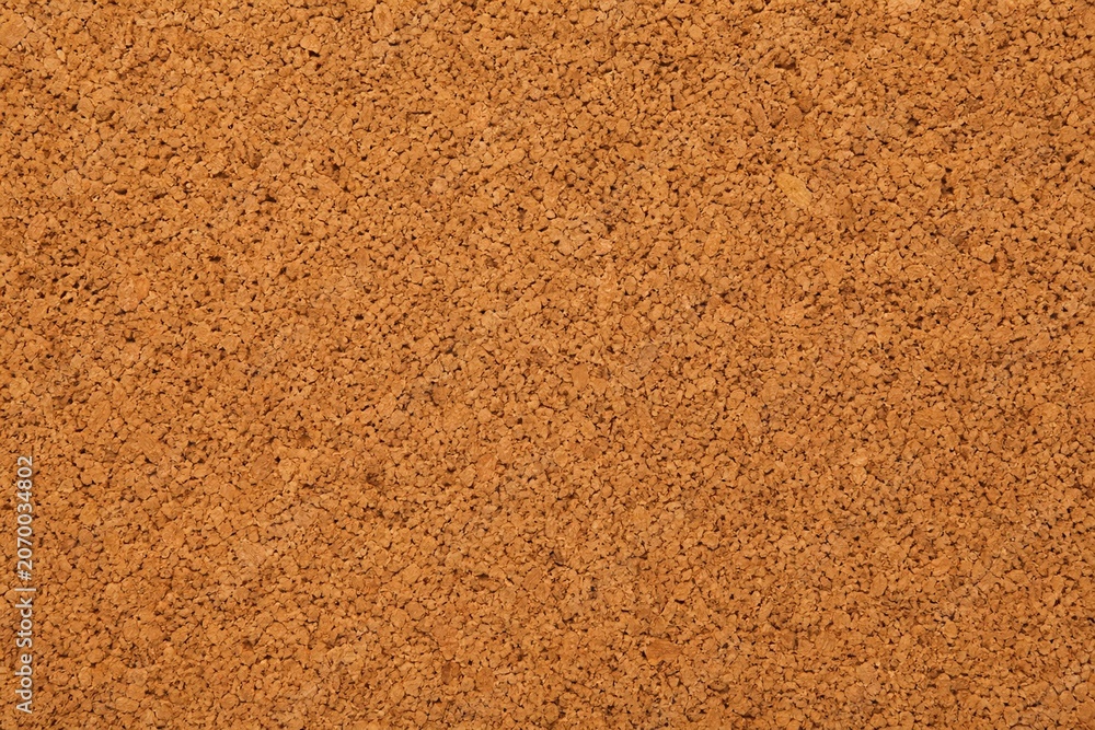 Fototapeta premium Close-up view of a natural cork's porous texture, showcasing warm brown tones on a minimalist background.