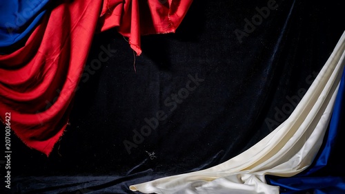 Flowing red white and blue fabric draped on dark background