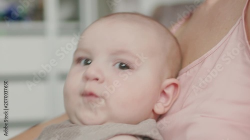 Teething baby lying down, chewing toy and moving hands and feet actively. Top view of sweet infant crying and smiling during first teeth growth milestone. Pediatric and parenting concept.