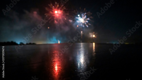 Colorful fireworks reflecting over calm water at night celebration