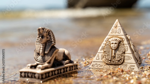 Quadro em tela Ancient lion statue rests beside pyramid model